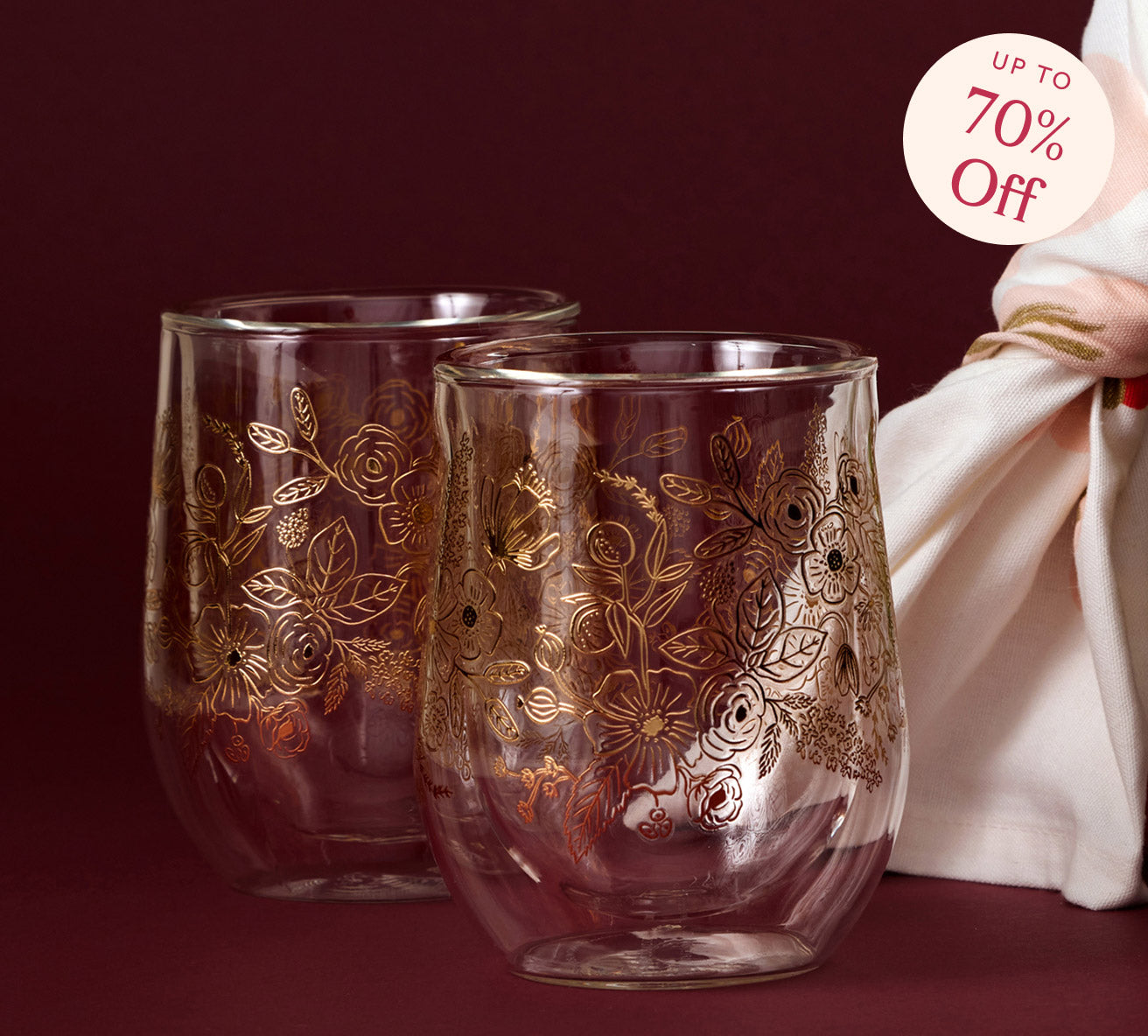 Two glass tumblers with floral patterns on a dark red background, with a discount label in the corner.