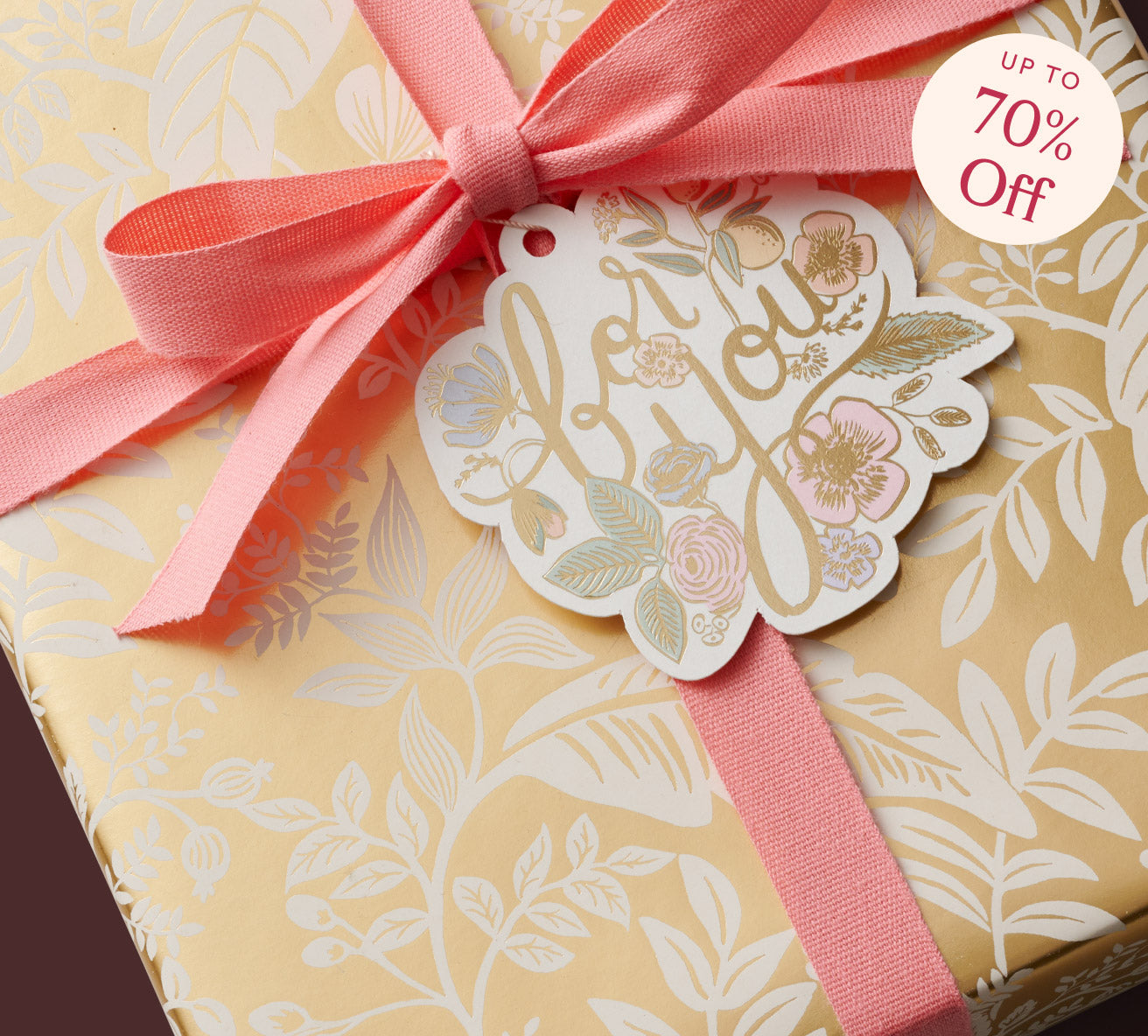 Gift box with floral tag and pink ribbon on a decorative background