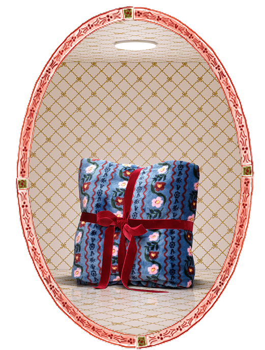 Folded fabric with floral patterns and a red ribbon on a decorative stand.
